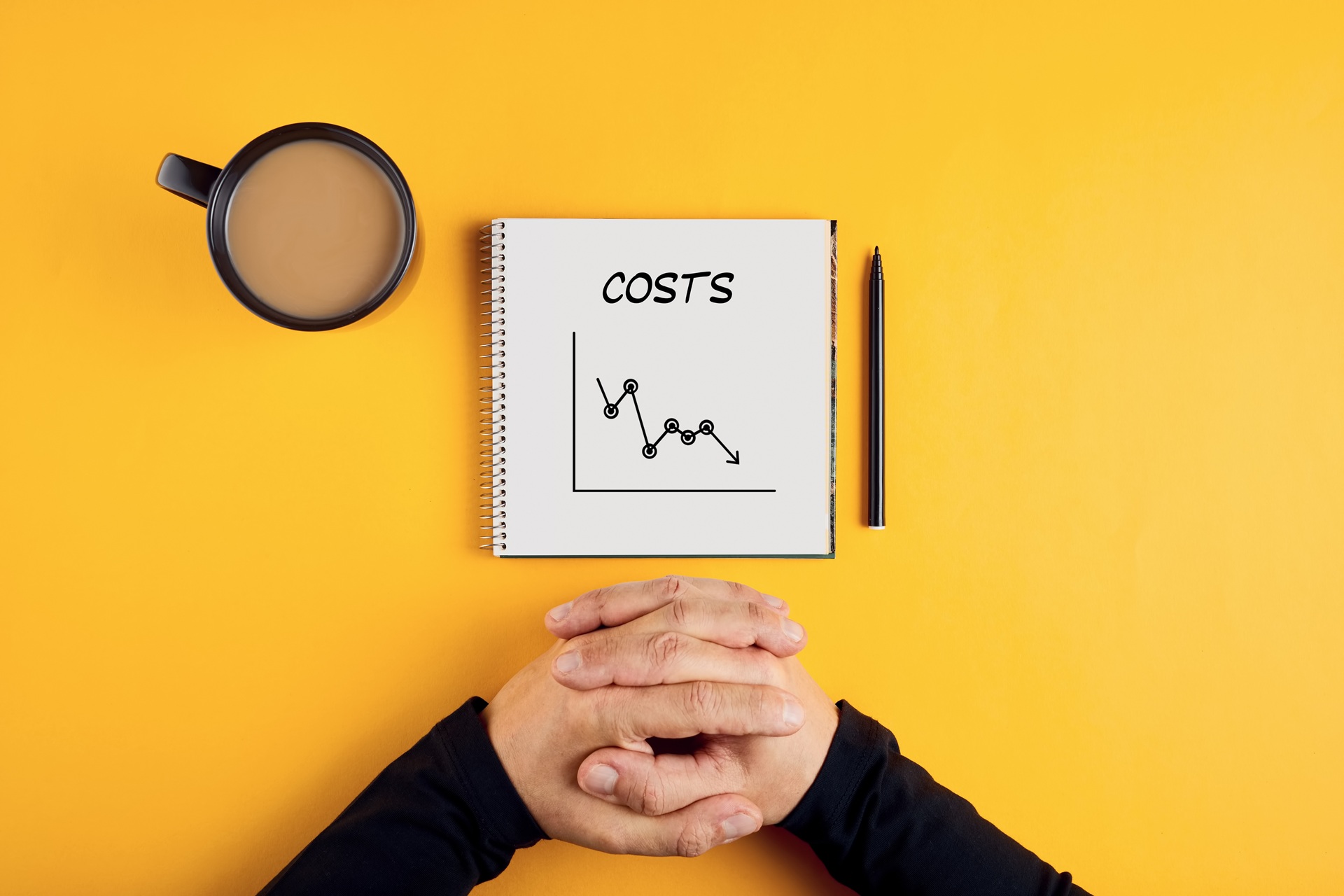 Diagramm mit sinkenden Kosten auf Notizbuch | modulares Bauen